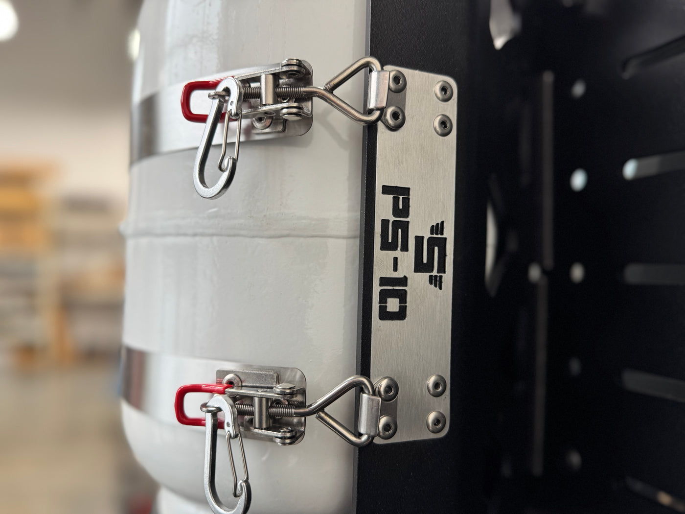 close-up of Shuksan PS-10 stainless badge on side of aluminum propane tank mount